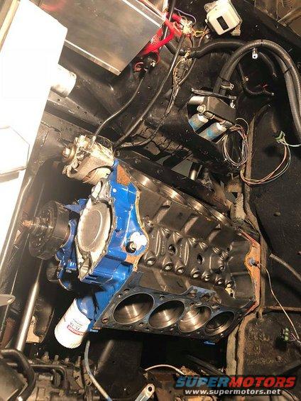 Engine block with oil filter, alternator, and wiring. Some blue paint on the block