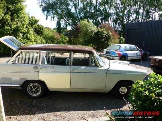 Station wagon with brown roof, side view. Another car with colorful paint is parked behind