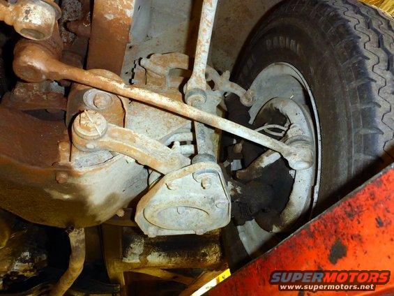 Underside view of rusty suspension parts and tire
