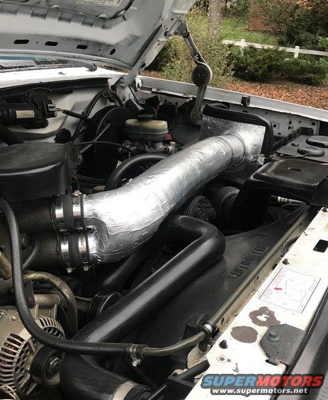 1995 Ford Bronco engine bay with custom intake and silver-wrapped tubing