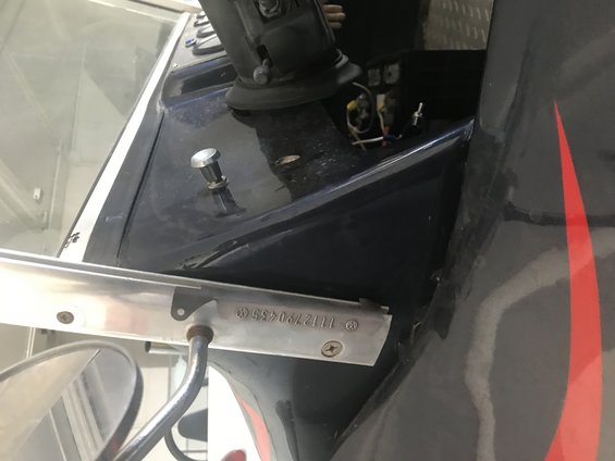 Boat interior showing dashboard and a VIN plate with numbers 1112790455