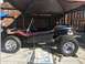 1970 Volkswagen Beetle - A custom dune buggy with flame decals sits under a canopy, parked on a concrete surface.