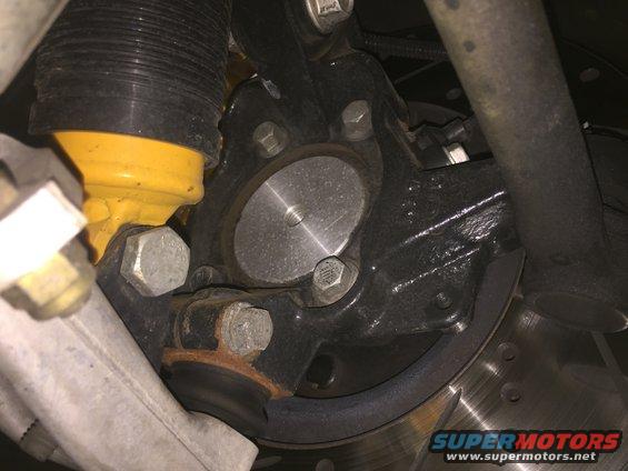 Close-up of a car's suspension with yellow shock absorber and brake rotor