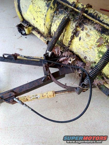 Yellow snow plow attachment with hydraulic cylinder and springs