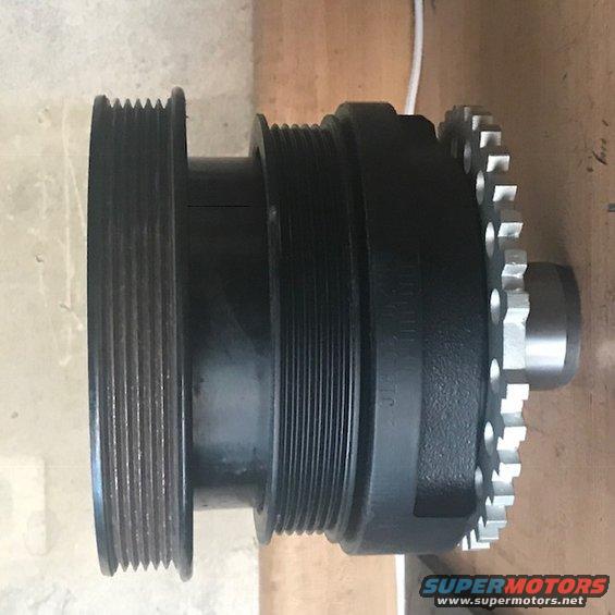 Black crankshaft pulley with multiple grooves and a silver timing gear attached