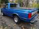 1994 Ford F-150 - A blue 1994 Ford F-150 pickup truck is seen from a three-quarter front view on an autumn day.