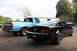 1994 Ford F-150 - A blue Ford pickup truck is parked next to a black Ford Mustang, with another car in the background.