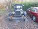 1909 Ford Model T - A vintage car with a distinctive grille is parked outdoors next to a modern sedan.