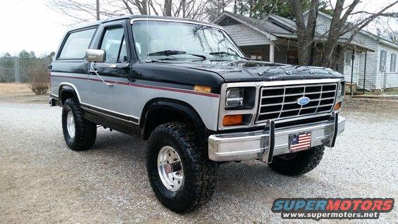Black and silver two-tone Ford Bronco with chrome grille and bumper, lifted suspension, and aftermarket wheels