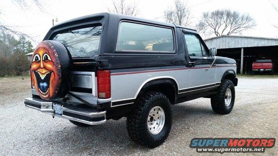 Rear 3/4 view of a 1986 Ford Bronco with a painted spare tire cover