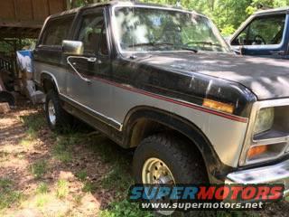 1986 Ford Bronco with two-tone paint and red stripe detail, parked outdoors
