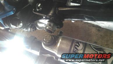 Close-up of a front axle suspension component and a FOX shock absorber