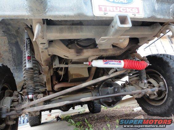 Underside view of a truck's rear axle and suspension with Skyjacker shocks. Ford Trucks license plate visible