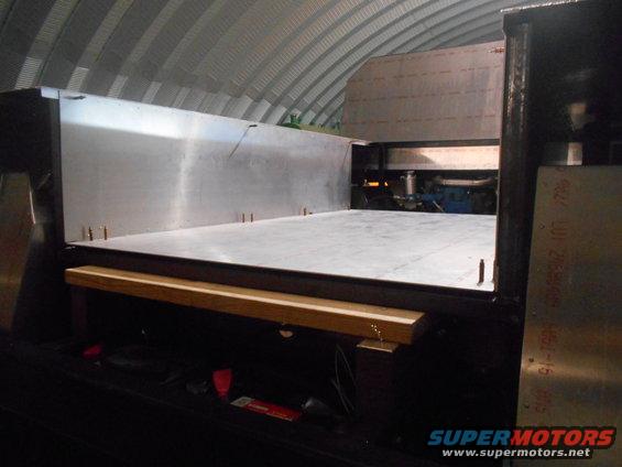 Custom flatbed truck bed interior with engine visible. Some text on side panel