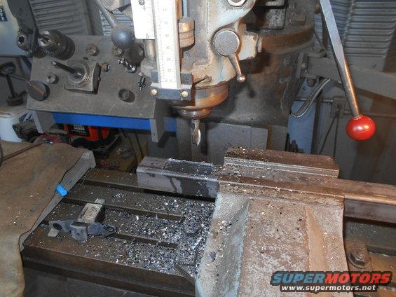 Milling machine cutting metal, metal shavings on table