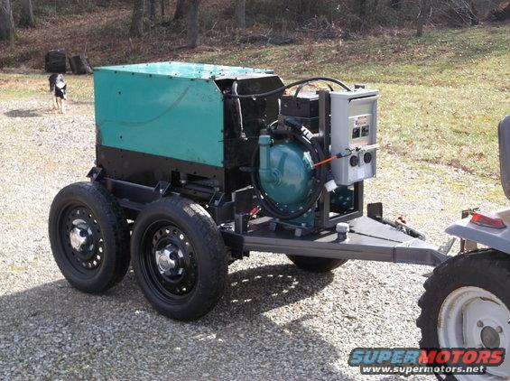 Trailer-mounted generator with teal housing and visible engine components