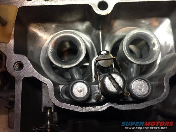 Carburetor interior with two intake ports, throttle plates, and adjustment screws