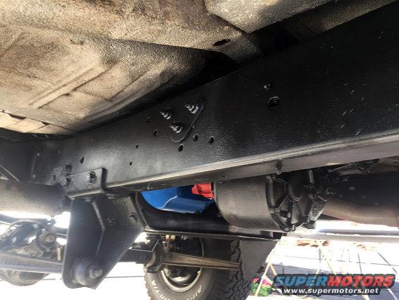 Underside view of a vehicle frame with suspension components and a transfer case visible
