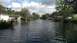 2006 Honda RANCHER - A suburban street is submerged in floodwaters, with several vehicles partially underwater.