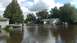 2006 Honda RANCHER - Residential street flooded with deep water, submerging parked vehicles.