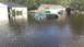 2006 Honda RANCHER - Flooding submerges a minivan, with another vehicle visible on dry land.