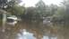 2006 Honda RANCHER - A neighborhood is submerged in floodwaters, with several vehicles partially underwater.
