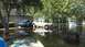 2006 Honda RANCHER - Two vehicles are partially submerged in floodwaters on a residential street.