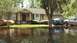 2006 Honda RANCHER - Multiple vehicles are partially submerged in floodwaters on a residential street.