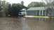 2006 Honda RANCHER - A white semi-truck is parked in a flooded driveway next to a residential house.
