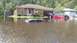 2006 Honda RANCHER - Multiple vehicles are submerged in floodwaters on a residential street.