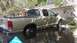 2006 Honda RANCHER - A tan pickup truck sits in floodwaters in front of a residential garage.