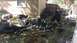 2006 Honda RANCHER - Various items including lawn equipment, tires, and gas cans are scattered in a cluttered backyard.