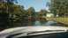 2006 Honda RANCHER - A suburban street is submerged in floodwaters, reflecting the surrounding trees and houses under a clear sky.