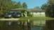 2006 Honda RANCHER - Two SUVs are parked in front of a house that is surrounded by floodwaters.