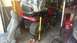 2006 Honda RANCHER - A red riding mower is elevated on blocks in a cluttered garage, with a car seat nearby.