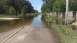 2006 Honda RANCHER - A flooded road with standing water, trees, and a wooden fence suggests a recent natural event.
