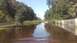 2006 Honda RANCHER - A flooded road with trees and a wooden fence on the right, reflecting the sky and surrounding vegetation. The Supermotors.net logo is visib…