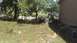 2006 Honda RANCHER - An ATV and a pickup truck are parked near a body of water next to a house.