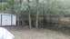 2006 Honda RANCHER - A backyard scene shows standing water behind a wooden fence, with a shed visible on the left.