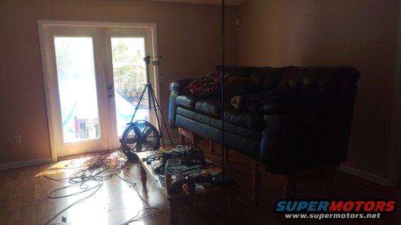 Dark leather sofa on wooden legs in a room with double doors and a fan