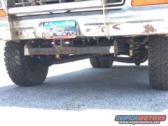 1979 Ford F-150 rear bumper with trailer hitch and visible suspension components. Chrome is rusted and peeling