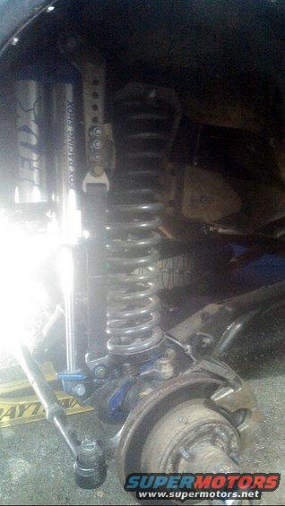 Close-up of a vehicle's front suspension with a Fox Racing Shox shock absorber and coil spring