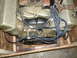 1956 Lincoln Continental - Engine part with gold valve covers and spark plug wires, mounted on wood.