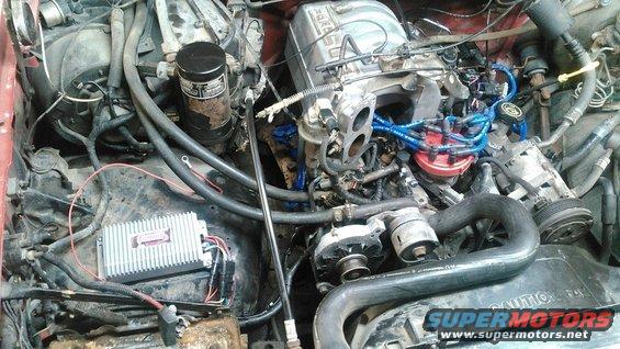 Engine bay of a 1991 Ford F-150 with visible ignition system and alternator