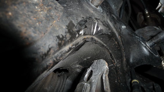 Close-up of damaged metal frame structure, possibly from a car's undercarriage