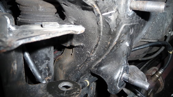 close-up of car's front suspension assembly with bolts and wiring