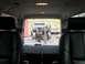 1992 Ford Bronco - View from inside a vehicle shows a disassembled truck on a hoist, with another truck parked behind it.