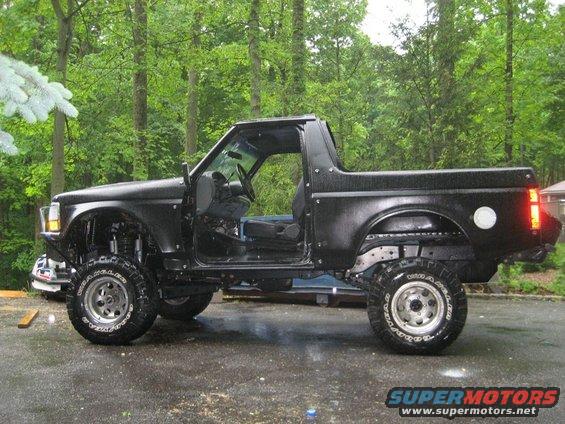 Black 1992 Ford Bronco side view, doors removed, lifted suspension