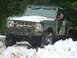 1990 Ford Bronco - Ford Bronco navigating a snowy trail with a driver visible inside.