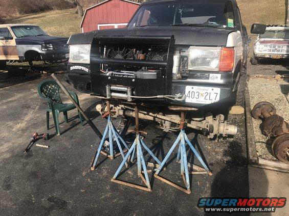Black Ford Bronco on jack stands, front end disassembled, winch installed, Maryland license plate 403 2L7